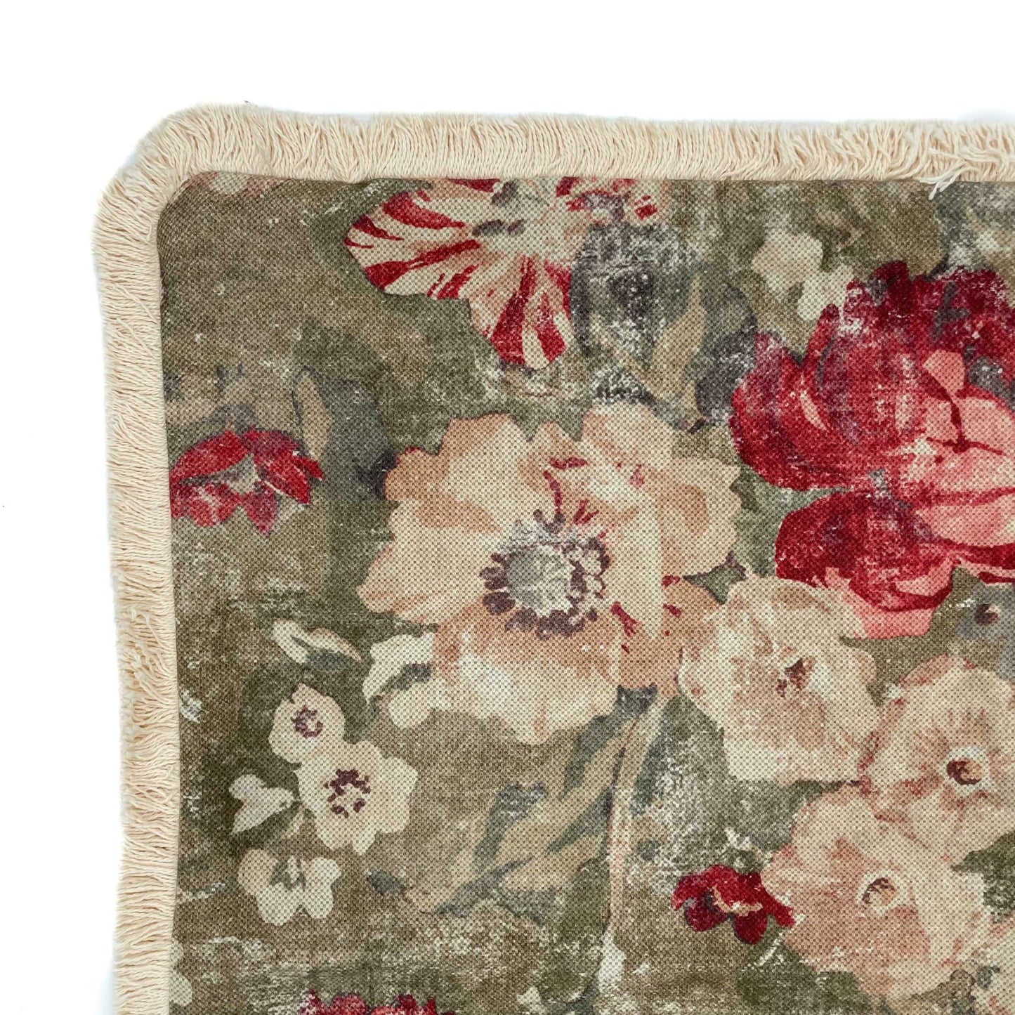 Floral patterned rug with red and beige flowers on a green background