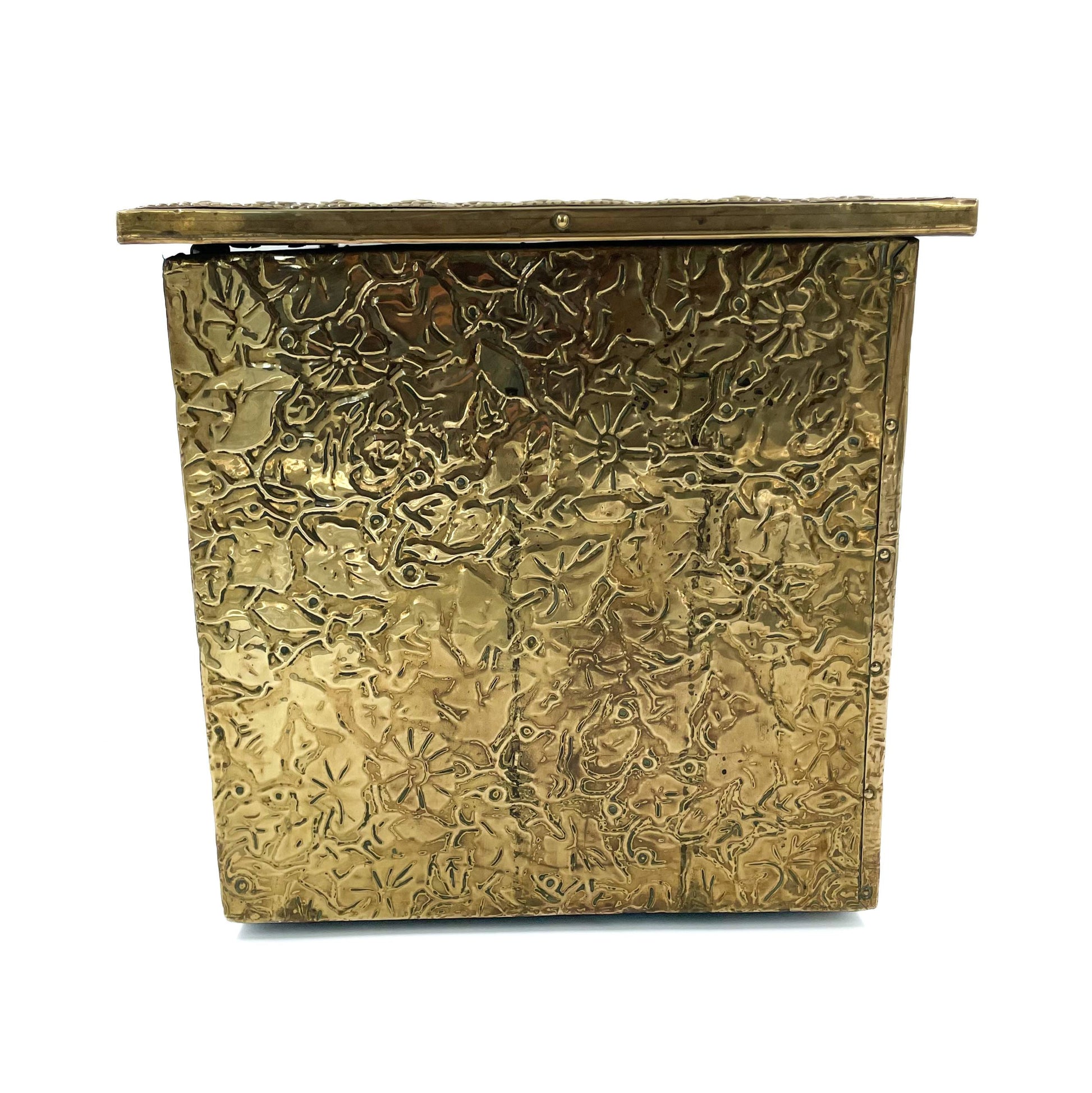 Side view of an embossed brass box from the late 19th century, crafted using repoussé techniques, depict a scenes of historical domestic life.