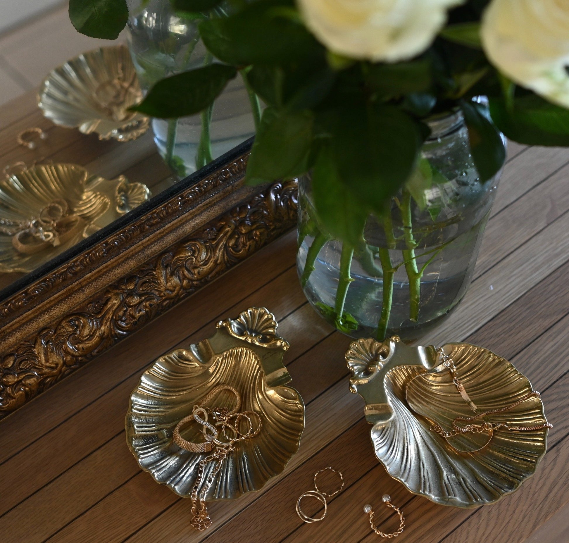 A pair of vintage shell dishes ,cast in gleaming brass with softly scalloped edges and ornate detailing at the base.