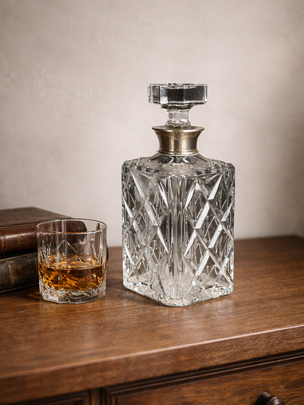 Crystal decanter with a glass on a wooden surface