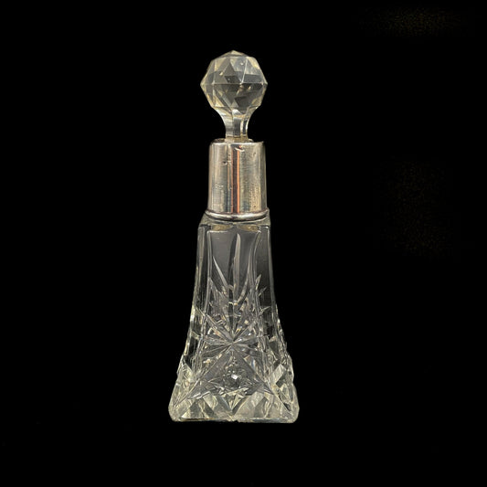 Perfume bottle with silver stopper on a black background