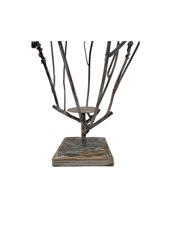 Decorative metal branch candle holder on a square base with a white background